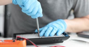 Erkek tamirci ışıklandırma ekipmanlarını tamir ediyor.