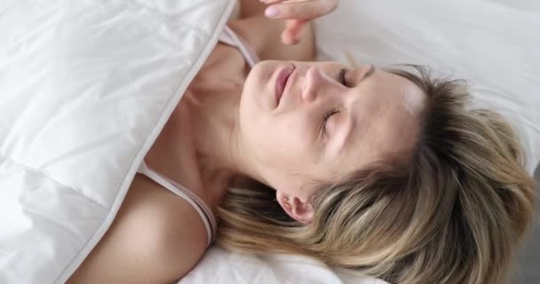 Wakker vrouw tilt de deken en kijkt in shock onder covers — Stockvideo