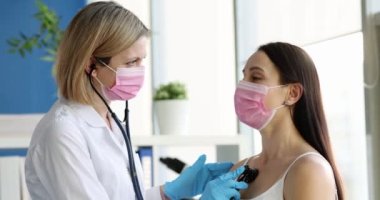 Doktor akciğerleri dinlemek için steteskop kullanıyor.