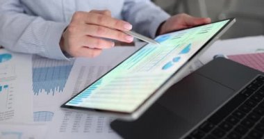 Elektronik cihazlar üzerinde çalışan muhasebeci tablet üzerinde mali rapor hazırlıyor