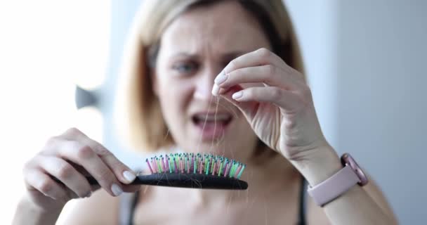 Kvinna förlorar hår på kam i handen närbild — Stockvideo