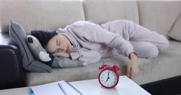 Mujer cubre las orejas con almohada cuando suena el despertador — Vídeos de Stock