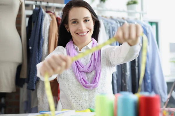 Sorrindo costureira mulher disposta a fita métrica você, descobrir o tamanho da roupa — Fotografia de Stock