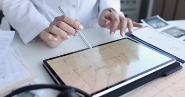Kardiyolog tablette elektrokardiyogram kalp atışı üzerine çalışıyor.