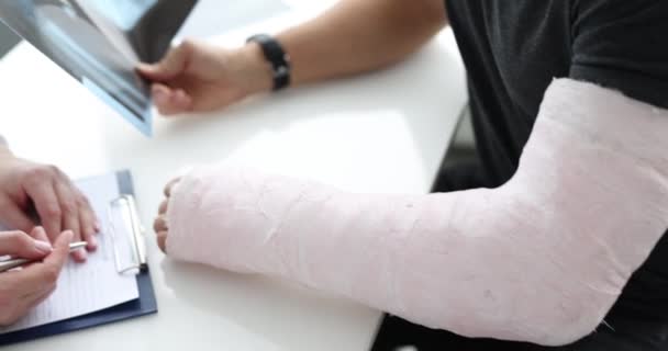 Törött karral és röntgennel rendelkező beteg az orvosi vizsgálatnál — Stock videók