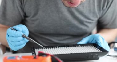 Tornavida denemesi kullanan mühendis lambayı kapatıyor