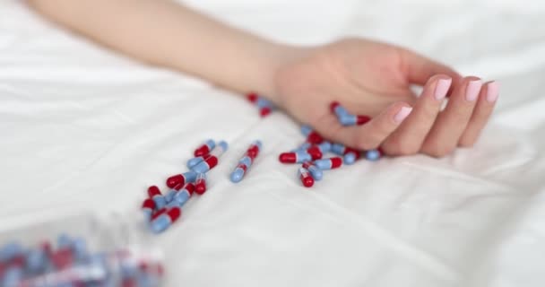 Mão feminina imóvel na cama com comprimidos close-up — Vídeo de Stock