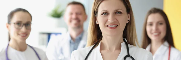 Портрет успешной женщины-врача на фоне коллег — стоковое фото