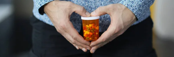 Man holding jar of capsules near genitals closeup — Stock Photo, Image