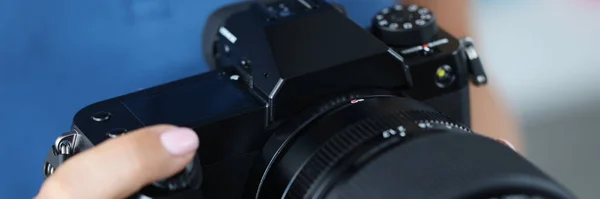 Mulher segurando câmera preta profissional em mãos e endireitando a lente close-up — Fotografia de Stock