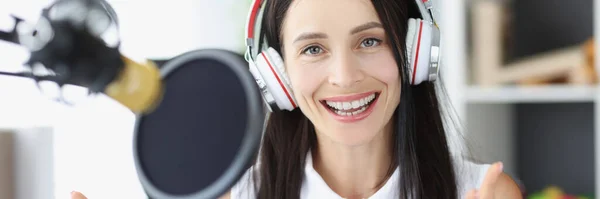 Apresentador de rádio jovem mulher sorrindo na frente do microfone — Fotografia de Stock
