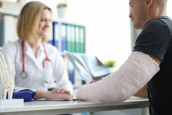 Klinikteki doktor randevusunda kolu kırılmış bir adam. — Stok fotoğraf