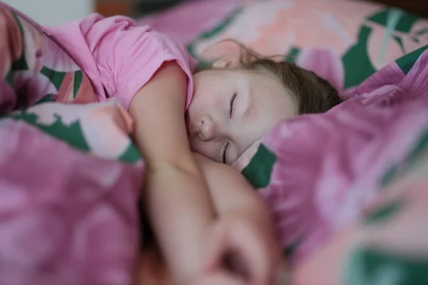 Bambina che dorme tranquillamente nel letto rosa a casa — Foto Stock