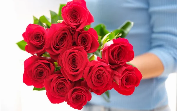 A nőnél egy csokor gyönyörű vörös rózsa van. — Stock Fotó