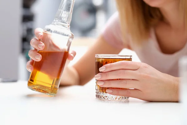 Mulher com garrafa de álcool e vidro sozinha — Fotografia de Stock
