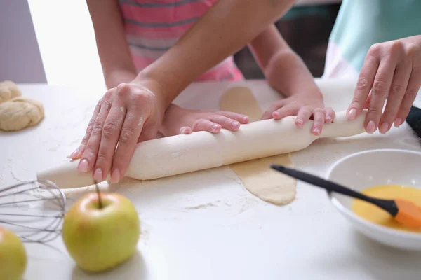 Mãe e filha rolar a massa com rolo de pino na cozinha — Fotografia de Stock