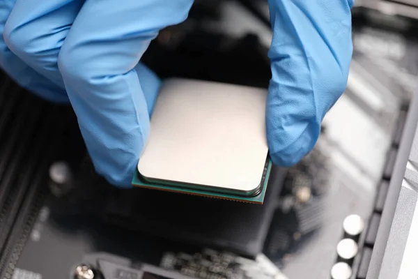 Technicien examine puce microprocesseur sur la carte mère PC — Photo