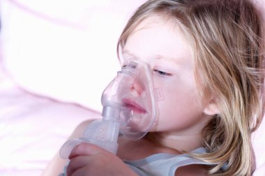 Nebulizör kullanan, tıbbi oksijen maskeli hasta küçük kız.