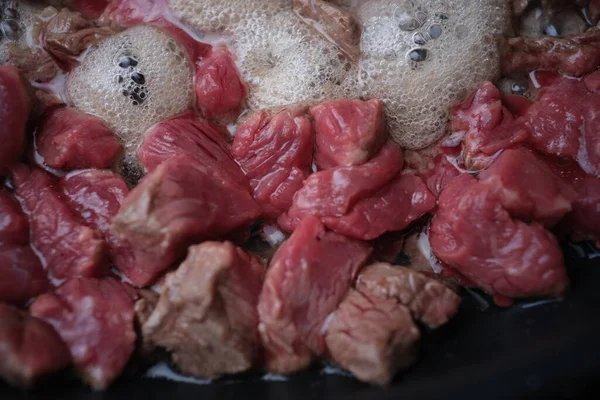 As partes de porco ou carne de vaca fritam-se na panela no óleo — Fotografia de Stock
