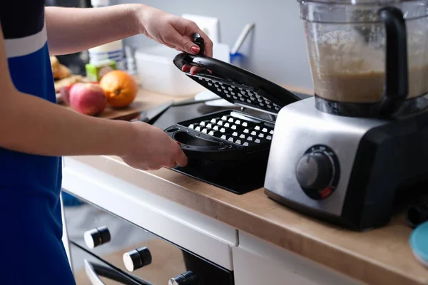 Kadın, Viyana ve Belçika gözlemeleri için elektrikli waffle makinesi açıyor.. — Stok fotoğraf