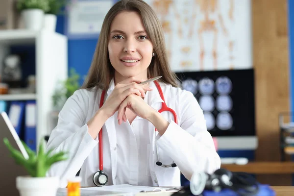 Smiling female doctor in gown, young medical specialist working in clinic — Stockfoto