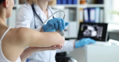Doctor conducts diagnostics of ultrasound of bones of hands of clinic