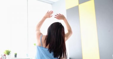 Sabah evde uyandıktan sonra kollarını geren kadının arka görüntüsü.