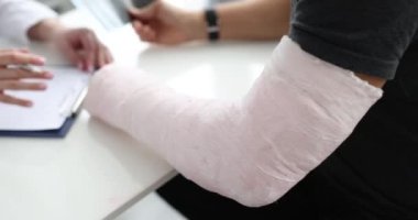 Man with plaster cast of his forearm and hand in rehabilitation center