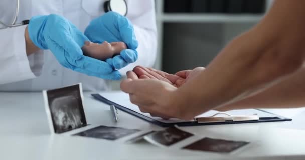 Doktor gynekolog předává model plodu dítěte ženě — Stock video