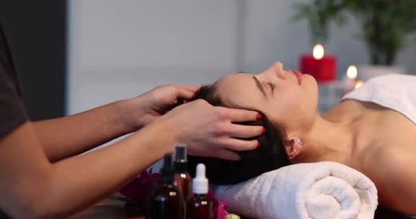 Masseuse makes head massage to woman in spa salon — Vídeo de Stock