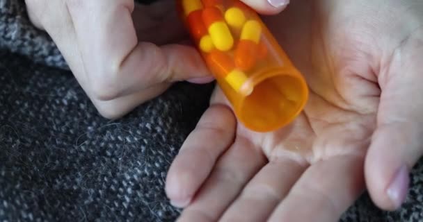 Person pours medical pills into palm of hand — Stok Video
