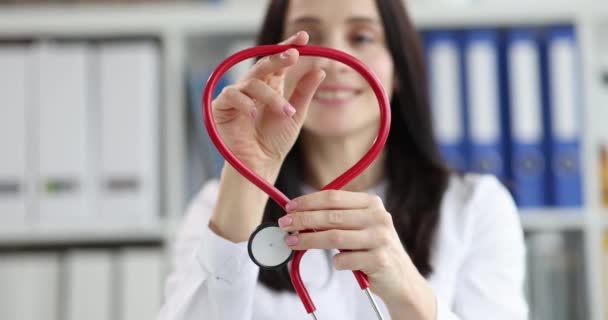 Кардиолог делает сердечный знак из медицинского стетоскопа — стоковое видео