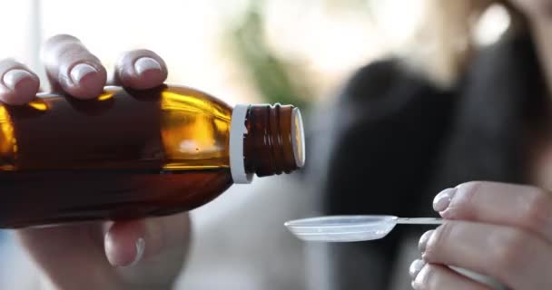 Woman pours cough syrup or antipyretics into spoon — Stok video