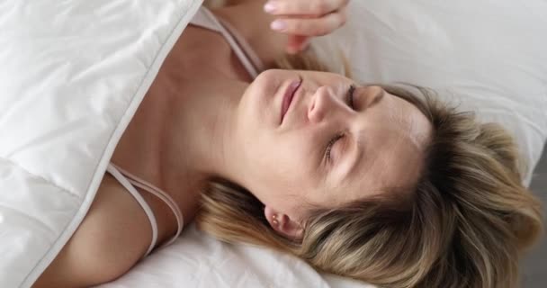 Awakened frightened woman looks under covers — Stok video