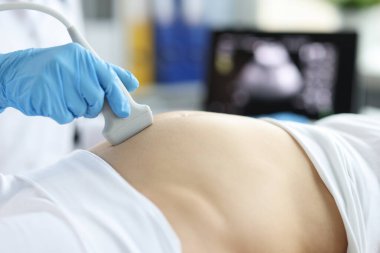 Gynecologist doing ultrasound scan on belly, pregnancy screening