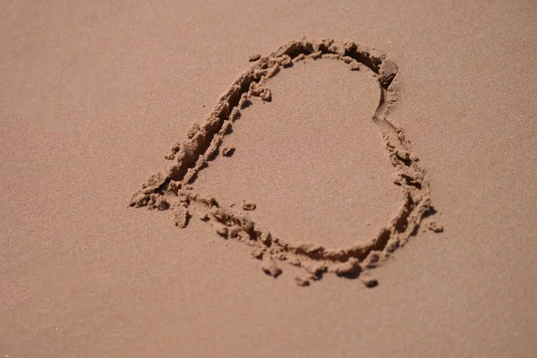 Drawn heart on wet sand on beach — Stockfoto