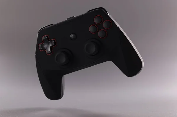 Black video game joystick or gamepad on grey background — ストック写真