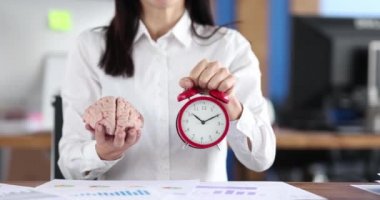 Businessman holding a brain and an alarm clock