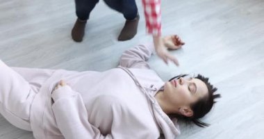 Biri nabzını kontrol eder ve yalancı kadına kalp masajı yapar.