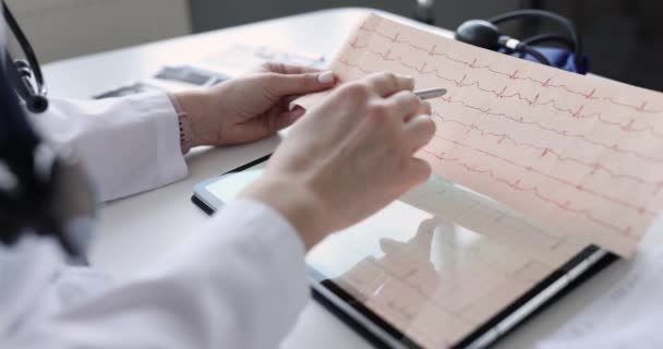 Doctor examines an electrocardiogram of patient after heart attack — Vídeo de stock