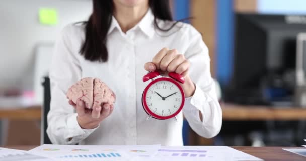 Empresario sosteniendo un cerebro y un despertador — Vídeos de Stock