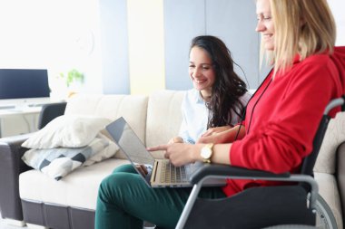 Bilgisayardaki fotoğraflara gülümseyen arkadaşlar, tekerlekli sandalyedeki kadın ve engelli insanlar.