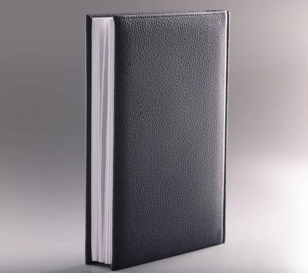 Black leather notebook or diary on grey background — Stock Photo, Image