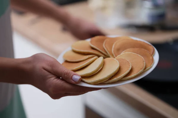 Weibliche Hände halten Teller mit leckeren hausgemachten Pfannkuchen — Stockfoto