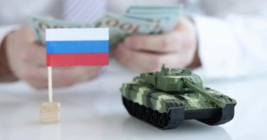 Rus bayrağı ve arka plandaki tank dolar sayıyor