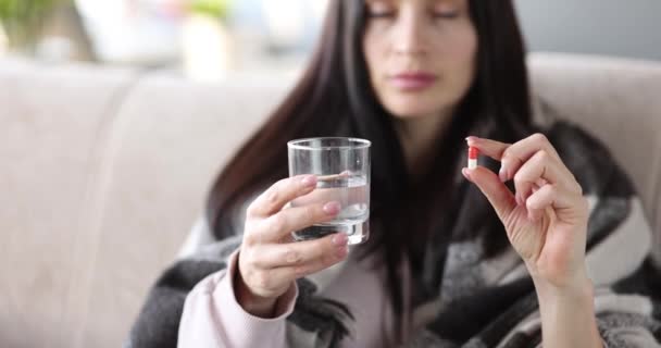 Woman holding pill and glass of water closeup — ストック動画