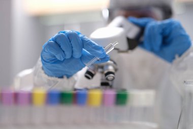 Scientist in laboratory holding syringe with liquid vaccines
