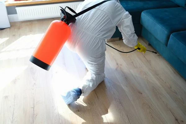 Człowiek w Hazmats dokonywania dezynfekcji w mieszkaniu — Zdjęcie stockowe