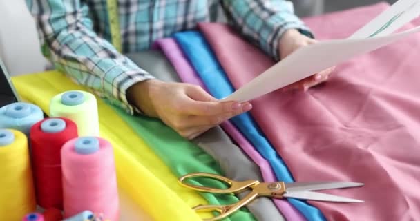 Designer-Stylist betrachtet Kleidungsskizzen auf Papier — Stockvideo