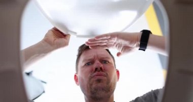 Adam tuvalet kapağını açıyor ve düşünceli görünüyor.